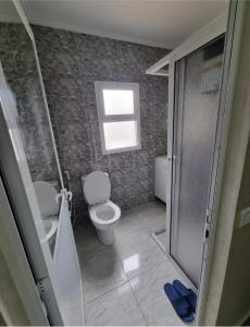 a small bathroom with a toilet and a window at Comforts apartments 1 in Fnidek