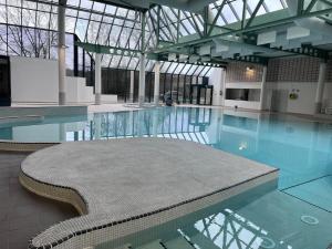 una piscina con un banco en un edificio en Enjoy Durbuy 5, en Durbuy