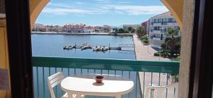 a balcony with a table and a view of a river at joli appart les pieds dans l'eau,terrasse et clim in Le Barcarès