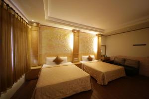una camera d'albergo con due letti e un divano di Goden Beach B&B a Eluan