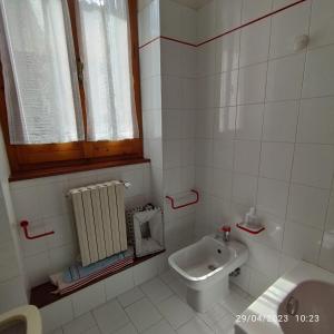 a white bathroom with a sink and a toilet at Casa Vacanze Corso Amendola in Bevagna +23 photos