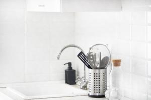 - un comptoir de cuisine avec évier et ustensiles dans l'établissement Apartamento Piletas, à Sanlúcar de Barrameda