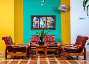 a living room with two chairs and a table with a vase at Hotel y Restaurante Mesón del Gitano in Caucasia