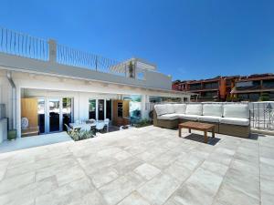 un patio con divano e tavolo su un edificio di Luxury sea view home/4-min walk to beach a Marinella