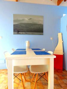 a dining room table with chairs and a painting on the wall at Casa do Cais in Monte