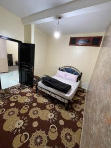 1 dormitorio con cama y alfombra grande en La Casa votre hébergement idéal, en Dakhla