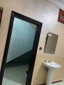 bagno con specchio e lavandino di La Casa votre hébergement idéal a Dakhla
