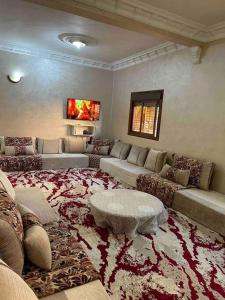 ein großes Wohnzimmer mit einem Sofa und einem Tisch in der Unterkunft La Casa votre hébergement idéal in Ad-Dakhla
