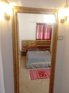a mirror reflection of a bedroom with a bed at Dar Chahla in Tozeur