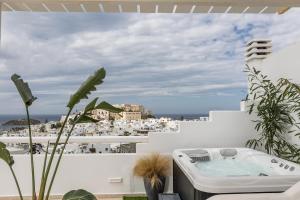 bañera de hidromasaje en el balcón con vistas a la ciudad en 37 2 Heaven, en Naxos Chora