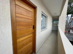 une porte en bois d'une maison avec un couloir dans l'établissement Expo Center - Apartamento 4, à São Paulo