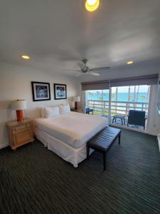 a bedroom with a large bed and a balcony at Sea Horse Resort in San Clemente