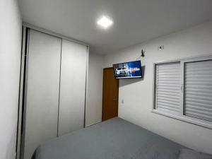 - une chambre avec un lit et une télévision murale dans l'établissement Expo Center - Apartamento 4, à São Paulo