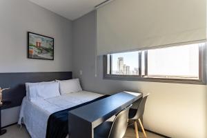 Schlafzimmer mit einem Bett, einem Schreibtisch und einem Fenster in der Unterkunft Studio confortável e moderno - Vn Vergueiro próximo a hospitais, universidades, a av Paulista e em frente ao centro cultural SP - excelente localização - ap 1515 in São Paulo