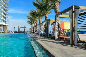 a swimming pool with palm trees and a resort at Spectacular Sunset Views Over the Ocean at Hollywood in Hollywood