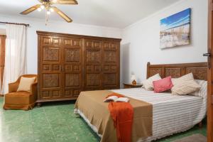 a bedroom with a large bed and a chair at Townhouse Can Bregat in Pollença