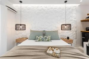a bedroom with a large bed with two pendant lights at Anatoli Hotel in Naxos Chora