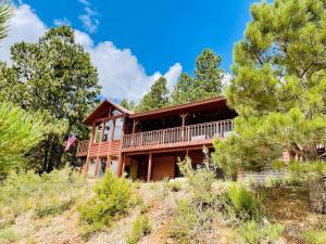 ein Blockhaus auf einem Hügel mit Bäumen in der Unterkunft Runway Cabin Retreat With Private Hot Tub! in Duck Creek Village