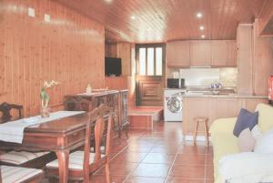 a living room with a table and a kitchen at Retiro de Várzeas . Casa de Turismo Rural in Vieira do Minho