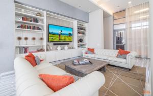 a living room with white furniture and a flat screen tv at Penthouses near Fulton Market-Cloud9-365 in Chicago