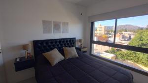 a bedroom with a bed and a large window at MaJo Apart in San Luis
