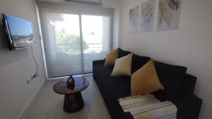 - un salon avec un canapé noir et une fenêtre dans l'établissement MaJo Apart, à San Luis