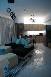 a living room with a couch and a kitchen at Poseidon's Premium Apartment in Katerini