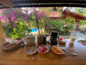 - une table en bois avec des bols de nourriture et une cafetière dans l'établissement A Piece of Paradise, à San Carlos