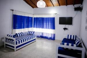 a living room with two couches and a tv at Cabaña Perla Azul in Coveñas