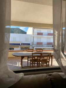 uma vista para uma mesa e cadeiras a partir de uma janela em La casa di Tonia em La Caletta