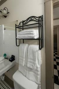 een badkamer met witte handdoeken op een rek boven het toilet bij Memphis Belvedere Suites Upper Queen loft 1 Bedroom in Memphis