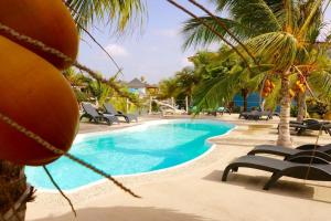 - une piscine avec des chaises longues et des palmiers dans l'établissement Loft Bahia Blue, à Kralendijk