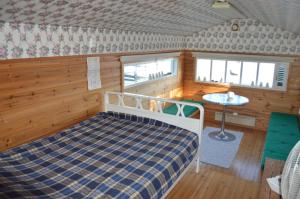 a bedroom with a bed and a table in a room at Vuosnaisten Meriasema in Kustavi