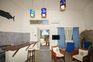 a living room with blue chairs and a table at Dimore di mare - Beachfront Apartments in Santa Flavia