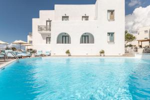 a villa with a swimming pool in front of a building at Anatoli Hotel in Naxos Chora