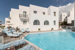 a villa with a swimming pool in front of a building at Anatoli Hotel in Naxos Chora