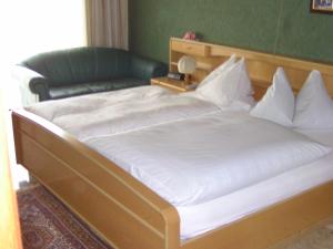 a large white bed in a bedroom with a green wall at Hotel zur guten Quelle in Selters