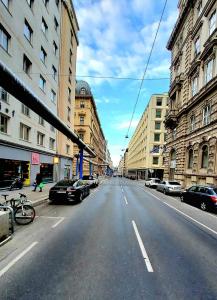an empty city street with parked cars and buildings at The Vast Core in Vienna