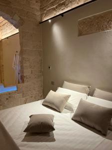 ein Schlafzimmer mit 2 Betten mit Kissen darauf in der Unterkunft BORGANTHIA - IL CHIOSTRO DEI MEDICI in Alberobello