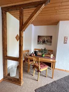 Habitación con mesa y techo de madera. en Landhaus Tannenhof en Lind