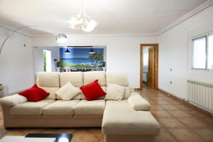 uma sala de estar com um sofá branco e almofadas vermelhas em 3 bedrooms villa with private pool enclosed garden and wifi at Linares em Jaén