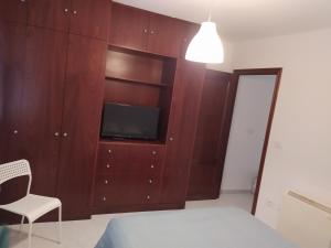 sypialnia z telewizorem w drewnianej szafce w obiekcie Vivienda en el casco histórico de Baiona w mieście Baiona