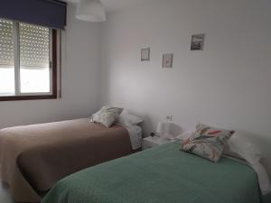 - une chambre avec 2 lits et une fenêtre dans l'établissement Vivienda en el casco histórico de Baiona, à Baiona
