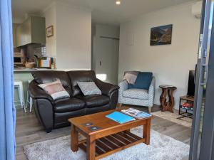 a living room with a leather couch and a coffee table at Cozy Cottage on Begg Lane in Cromwell