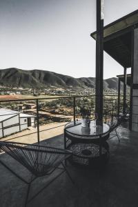 a table and chairs on a balcony with a view at Origen75 Loft - Villas - Skypool - Viñedo, Valle de Guadalupe in Valle de Guadalupe