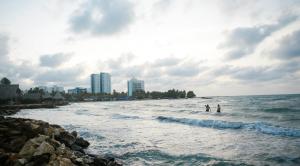 two people standing in the water at the beach at Cabaña Perla Azul in Coveñas