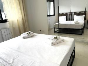 a bedroom with two white beds and a mirror at Appartement Luxueux aux jardins de Carthage in Sidi Daoud