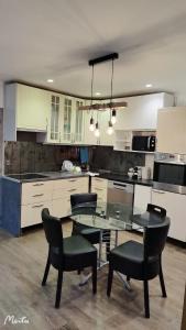 a kitchen with a glass table and black chairs at home, sweet home in Vitry-sur-Seine +28 photos