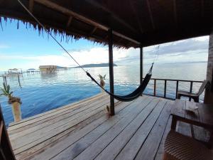 a hammock on a dock with the water at Lalosi Homestay in Besir