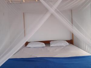a white bed with two pillows in a tent at Lalosi Homestay in Besir